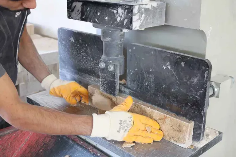 Stone veneer being split and shaped by hand